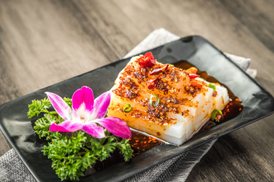 棕色木纹桌面上放着一盘酸辣凉粉