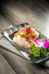 棕色木纹桌面上放着一盘酸辣凉粉