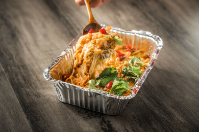 棕色木纹桌面上放着一份锡纸烧烤金针菇