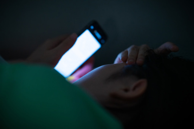 夜里黑灯瞎火关灯黑暗中玩手机的中国近视眼女人
