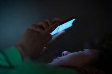 夜里黑灯瞎火关灯黑暗中玩手机的中国近视眼女人