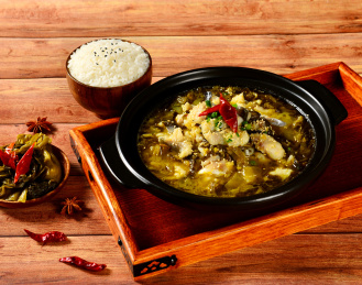 黑色砂锅中的酸菜水煮鱼和米饭