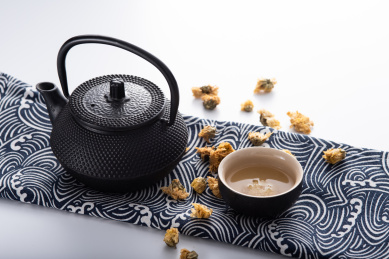 灰色背景上放着茶席铁茶壶菊花茶