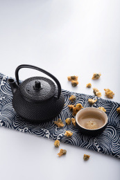 灰色背景上放着茶席铁茶壶菊花茶