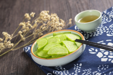 保健蔬菜青萝卜片盛放在盘子中摆放在桌面上