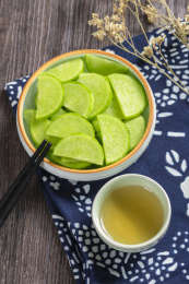 保健蔬菜青萝卜片盛放在盘子中摆放在桌面上