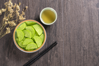 保健蔬菜青萝卜片盛放在盘子中摆放在桌面上