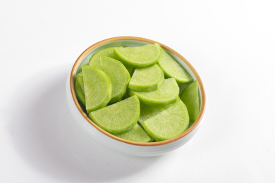 保健蔬菜青萝卜片盛放在盘子中摆放在桌面上