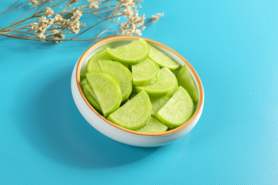 保健蔬菜青萝卜片盛放在盘子中摆放在桌面上