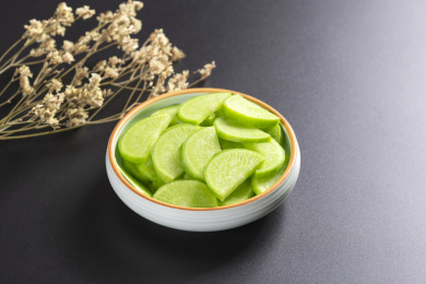 保健蔬菜青萝卜片盛放在盘子中摆放在桌面上