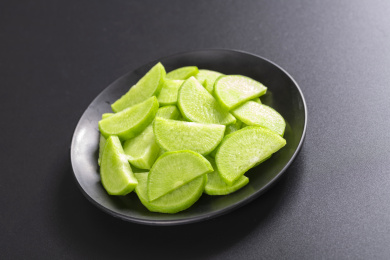 保健蔬菜青萝卜片盛放在盘子中摆放在桌面上