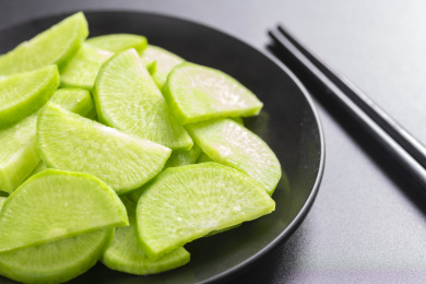 保健蔬菜青萝卜片盛放在盘子中摆放在桌面上