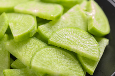 保健蔬菜青萝卜片盛放在盘子中摆放在桌面上