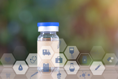 虚化的绿植背景前一瓶疫苗药品