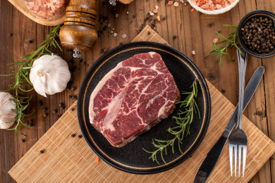 一片新鲜和牛雪花牛排m6放在木板背景上盘子里