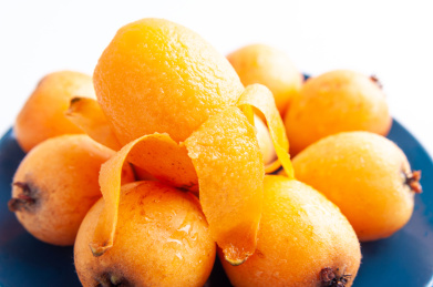 白色背景上的一盘新鲜枇杷果