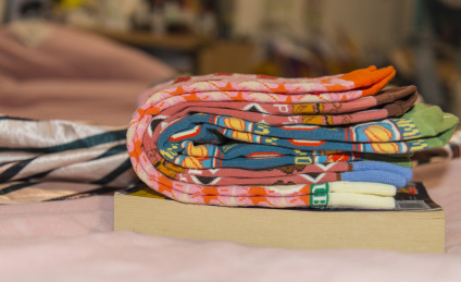 室内一叠五颜六色袜子放在床上面