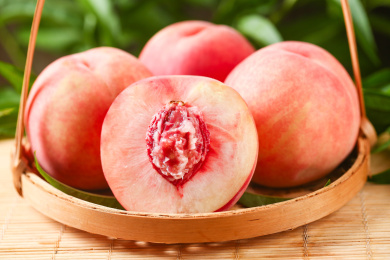 木底篮子上的鲜桃果肉切面