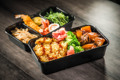 暗色木纹卓上放着一份红烧肉炸猪排双拼米饭套餐