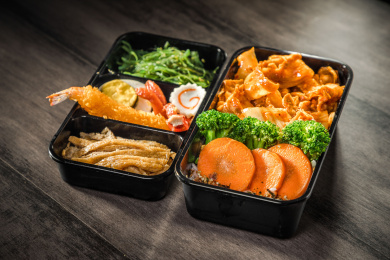 暗色木纹卓上放着一份酸辣五花肉日料米饭套餐