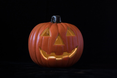 万圣节节日主题鬼脸南瓜灯放在黑色背景上