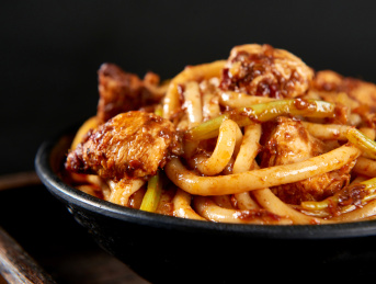 深色背景下的新疆特色鸡肉炒米粉