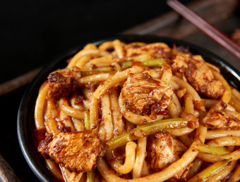深色背景下的新疆特色鸡肉炒米粉