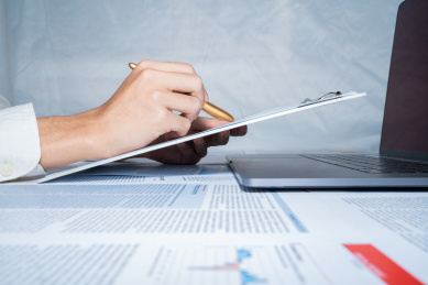 商务人士拿着办公夹和报表金色钢笔分析数据行情财经金融经济概念