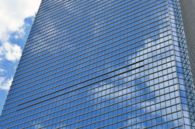 现代城市商业建筑蓝色镀膜玻璃幕墙背景特写