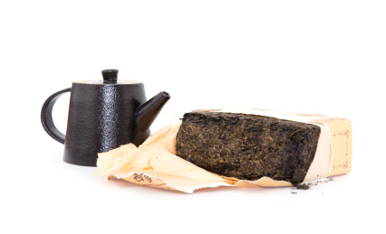 白背景上半块砖茶和一个粗瓷茶壶