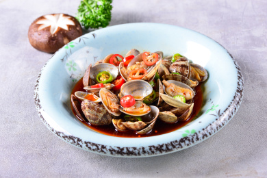 一盘凉拌红油玉螺凉菜放在灰色底板上