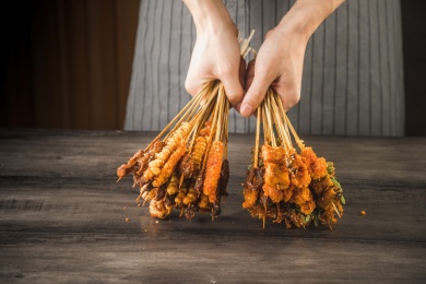 一位厨师在桌子前双手拿着油炸小串