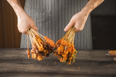 一位厨师在桌子前双手拿着油炸小串