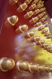 光影下的红色宫门上镶嵌着金黄色的门钉