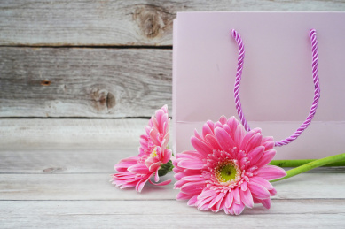 放在木板上的手提袋和粉红色大丽菊菊花