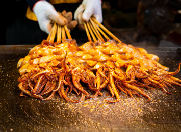 正在铁板上烤制的中国传统美食香辣烤鱿鱼