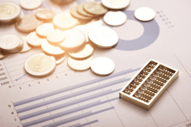金融经济数据增长概念——放在财务数据报表上的硬币和算盘