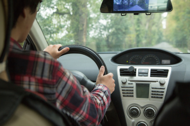 双手开车的成年男子