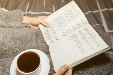 一个人在温暖的被子上看书学习放松喝咖啡喝奶茶