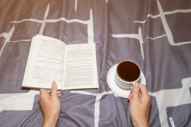 一个人在温暖的被子上看书学习放松喝咖啡喝奶茶