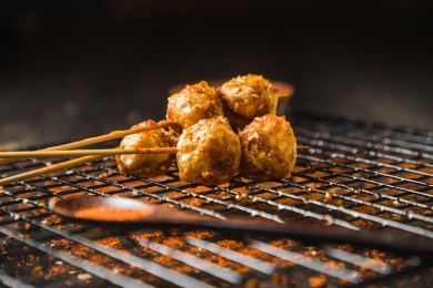 黑色烤架上放着几串撒着辣椒面的油炸鱼丸_站酷海洛_正版图片_视频