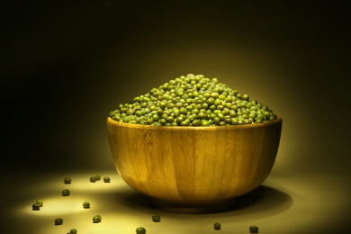 装满绿豆的木碗放在黑色背景上