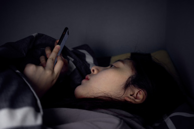 一个人躺在床上躲在被窝里看手机玩手机失眠被蓝光损害眼睛