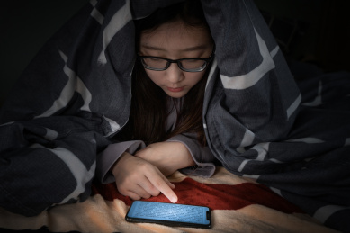 一个人躺在床上躲在被窝里看手机玩手机失眠被蓝光损害眼睛