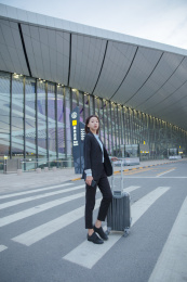 一位商务女士拉着拉杆箱过斑马线