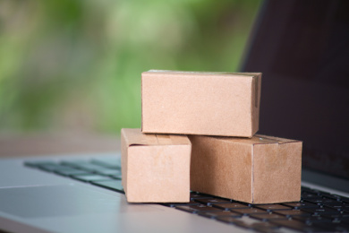 笔记本电脑键盘上放着迷你型快递包裹