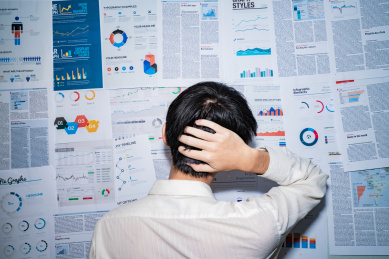 金融人士面对满墙的报表图表报告感到烦恼不明白而苦恼