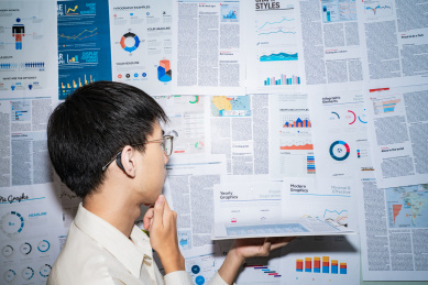 一个金融人士看着金融图表报表报告正在思考安排投资计划