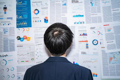 一个金融人士男人面对满墙白板上的报表报告统计数据加班分析研究思考