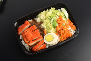 摆放在黑色桌子上的外卖蜜汁鸡排饭